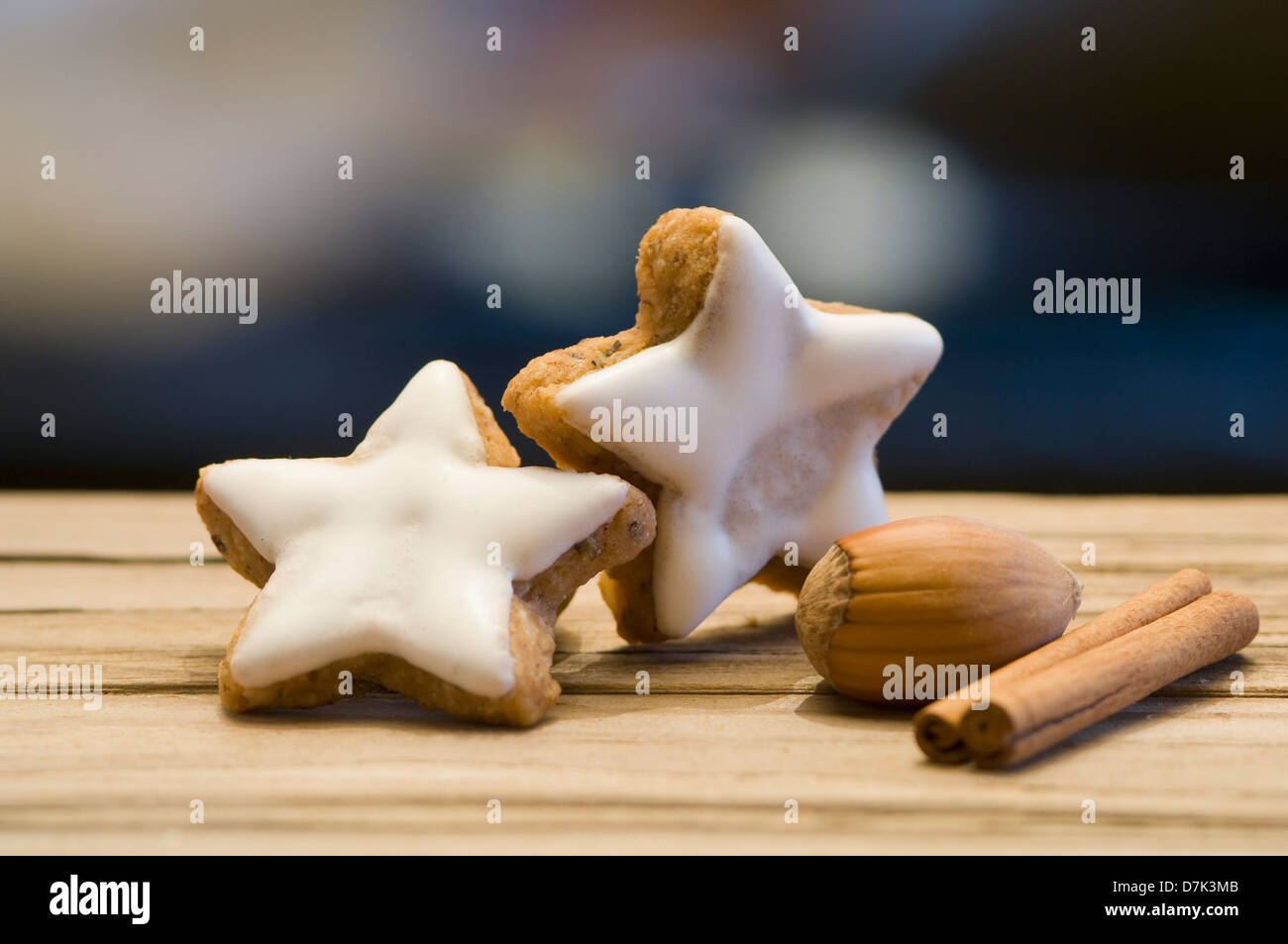 Star shape cinnamon cookies with cinnamon sticks and hazelnuts on table Stock Photo