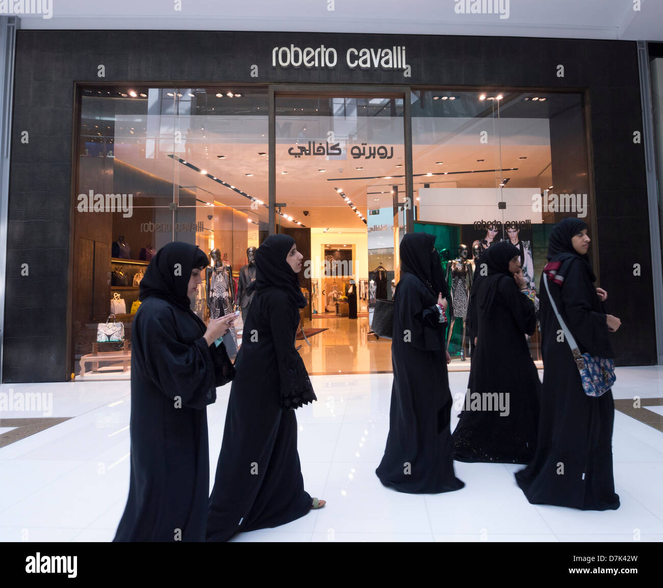 Arab women walk past Roberto Cavalli ashion boutique in The Dubai Mall in Dubai United Arab Emirates Stock Photo