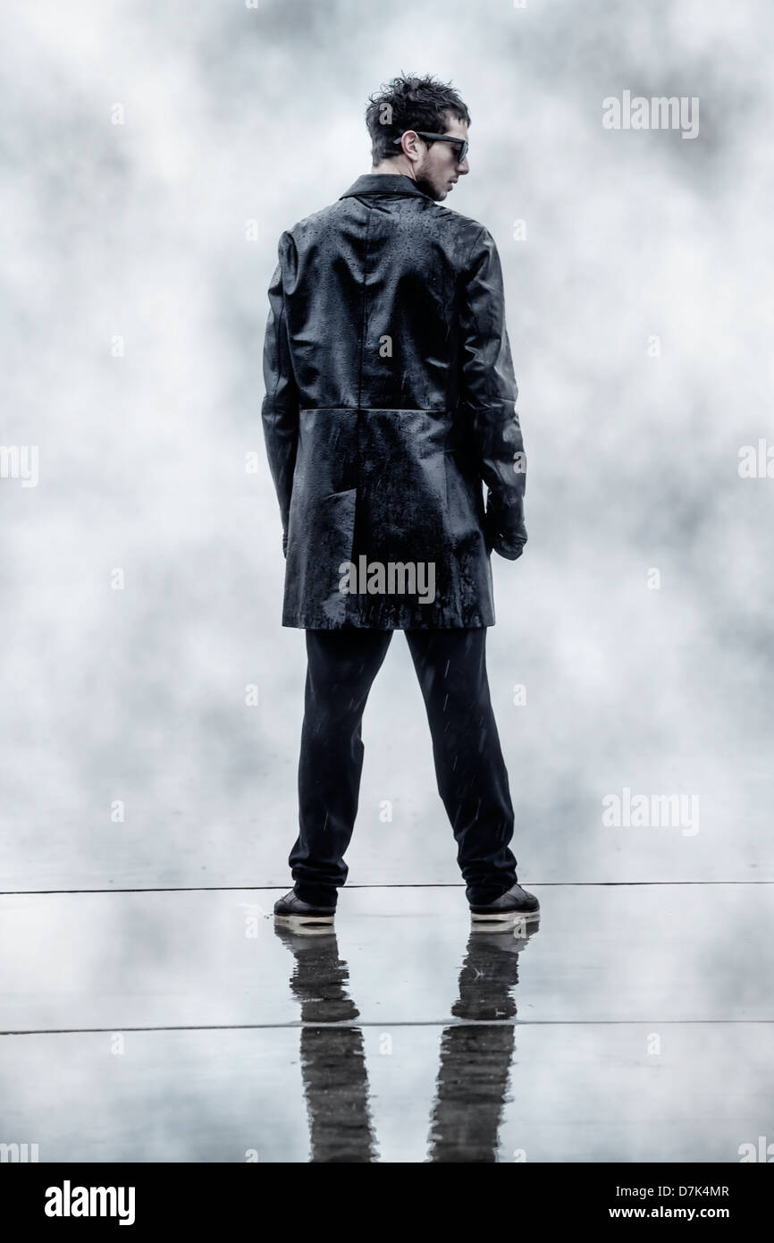 a sinister man in a black wet leather jacket during rain Stock Photo Alamy