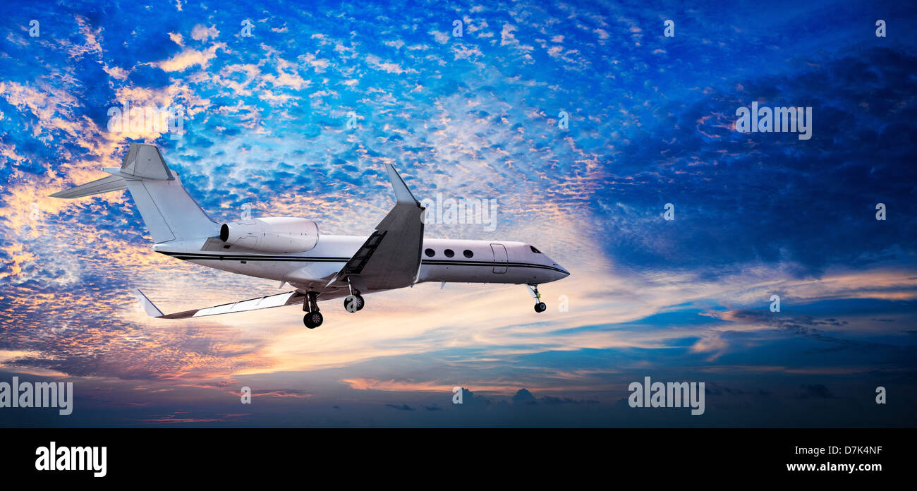 Panoramic composition of small private jet in a sunset sky Stock Photo