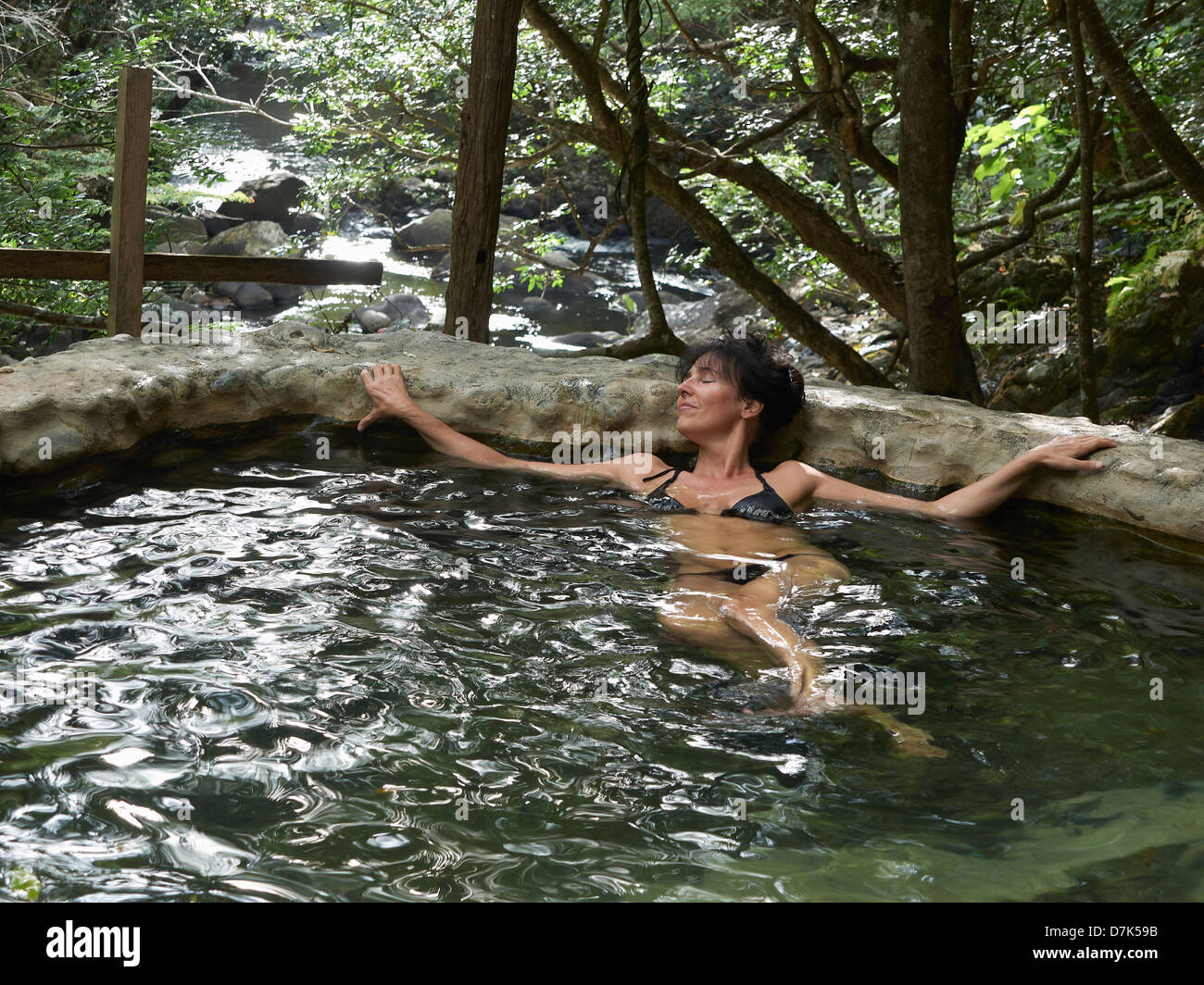 Central America, Costa Rica, Woman relaxing in hot spring at Las Pailas Stock Photo