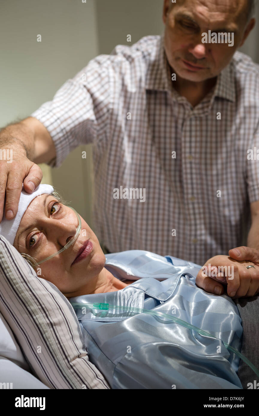 Loving husband taking care of seriously sick mature wife Stock Photo