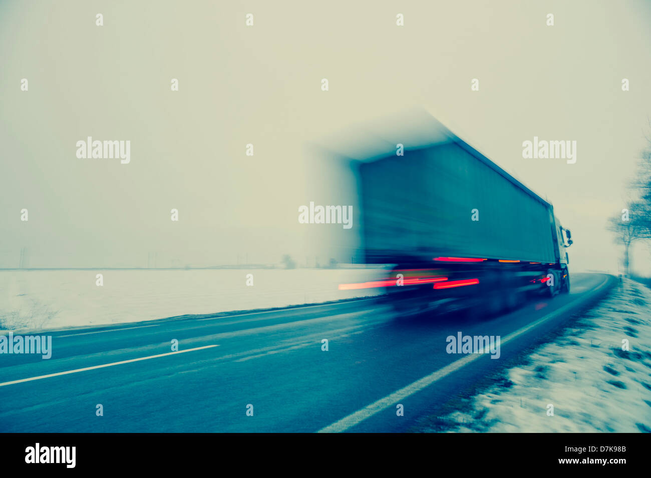 Austria, Cargo truck moving on country road in winter Stock Photo