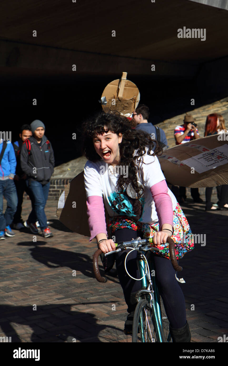 Laughing girl riding a bicycle and canvassing for student union elections at University of Sheffield South Yorkshire England Stock Photo