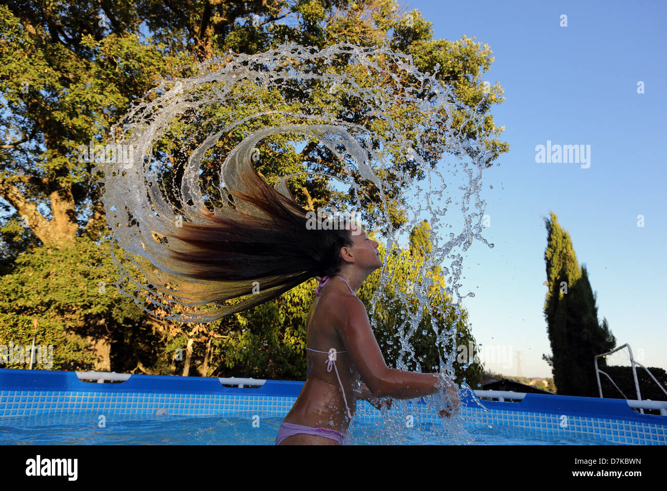 Torre Alfina, Italy, girl throws her wet hair back in swimming pool