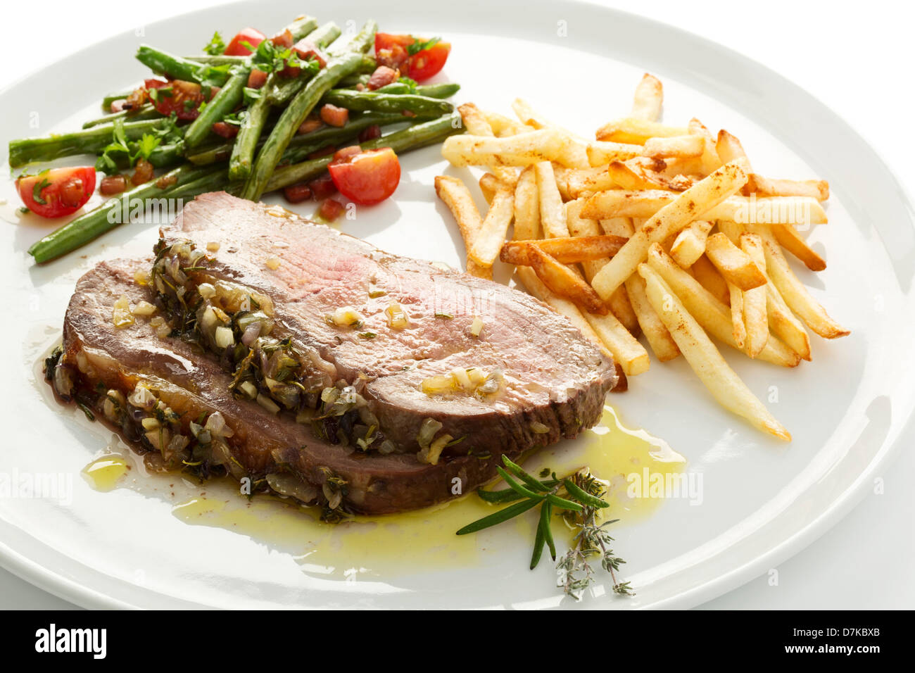 Roast beef, green beans and french fries on plate, close up Stock Photo