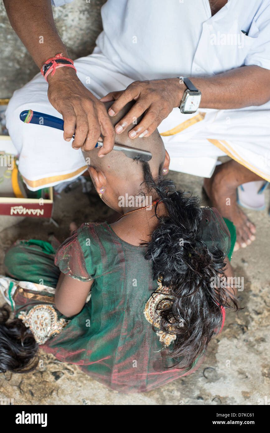 A young Hindu devotee has her head shaved as a sacrifice at the Arunachaleswara Temple in Tiruvannamalai, Tamil Nadu, India Stock Photo
