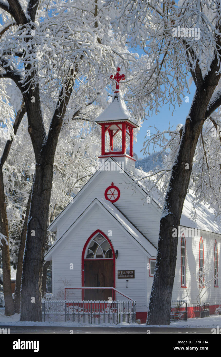 An old Victorian church building, now used as a Chamber of Commerce headquarters, is brightened by the fresh snow around it. Stock Photo