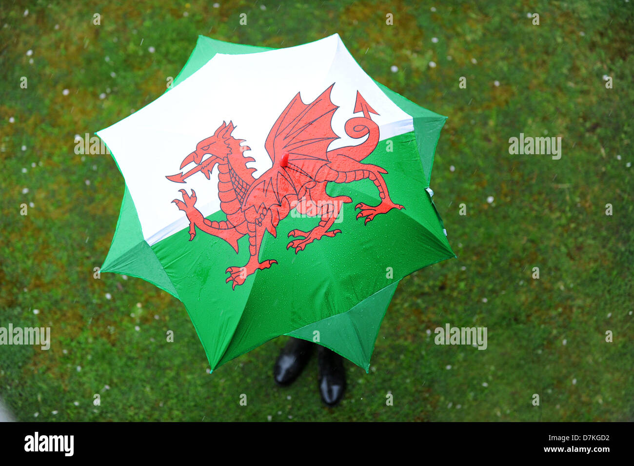 Cardiff, Wales, Uk. 9th May 2013.   A girl uses an umbrella to shelter from the rain in Rhiwbina, Cardiff. More wet weather has been forecast for the weekend. Credit: Matthew Horwood /Alamy Live News Stock Photo
