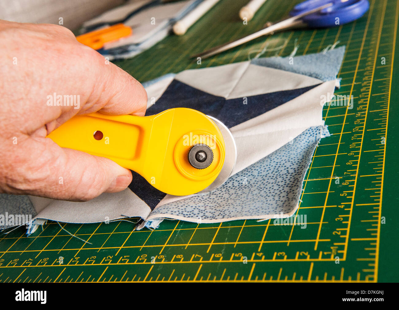Quilting patchwork materials on a green measuring board with scissors