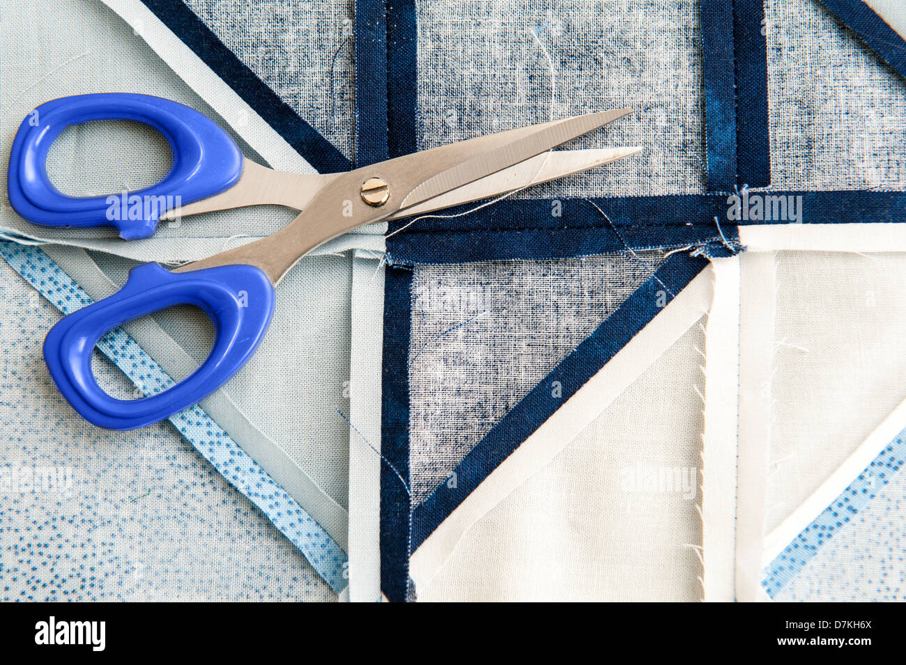Quilting or patchwork materials and tools with scissors showing blue and white patterned fat quarters Stock Photo