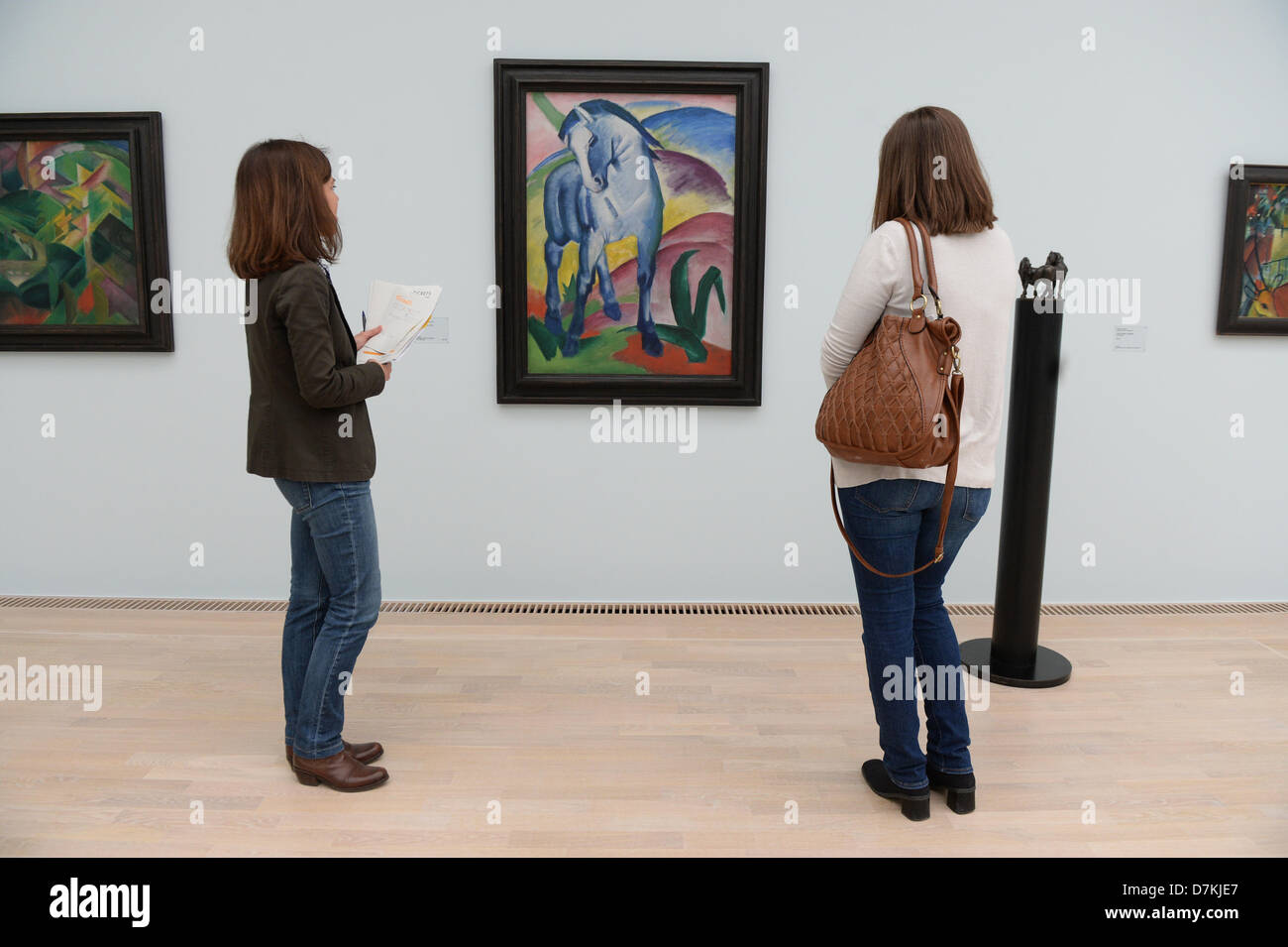 Visitors looks at the painting 'Blue Horse 1' by Franz Marc in the new Lenbachhaus in Munich, Germany, 06 May 2013. The Lenbachhaus opens to the public on 08 May after renovation works have been completed. Photo: FELIX HOERHAGER Stock Photo