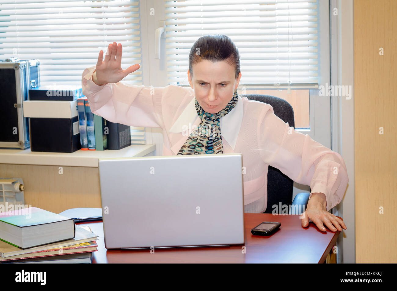 A fifty years old woman very angry with the modern technology Stock Photo