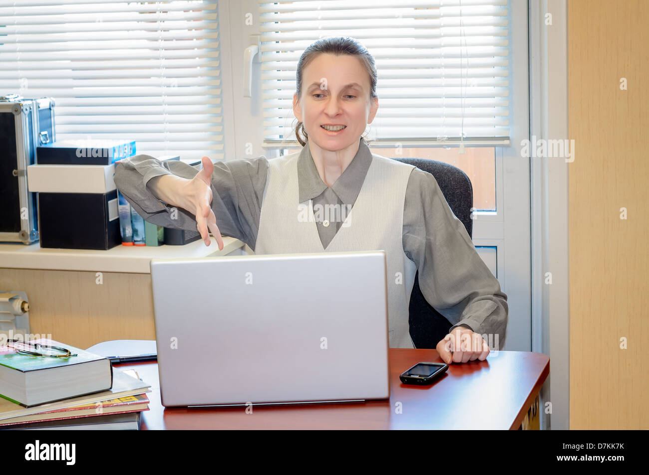 A fifty years old woman very angry with the modern technology of computer Stock Photo