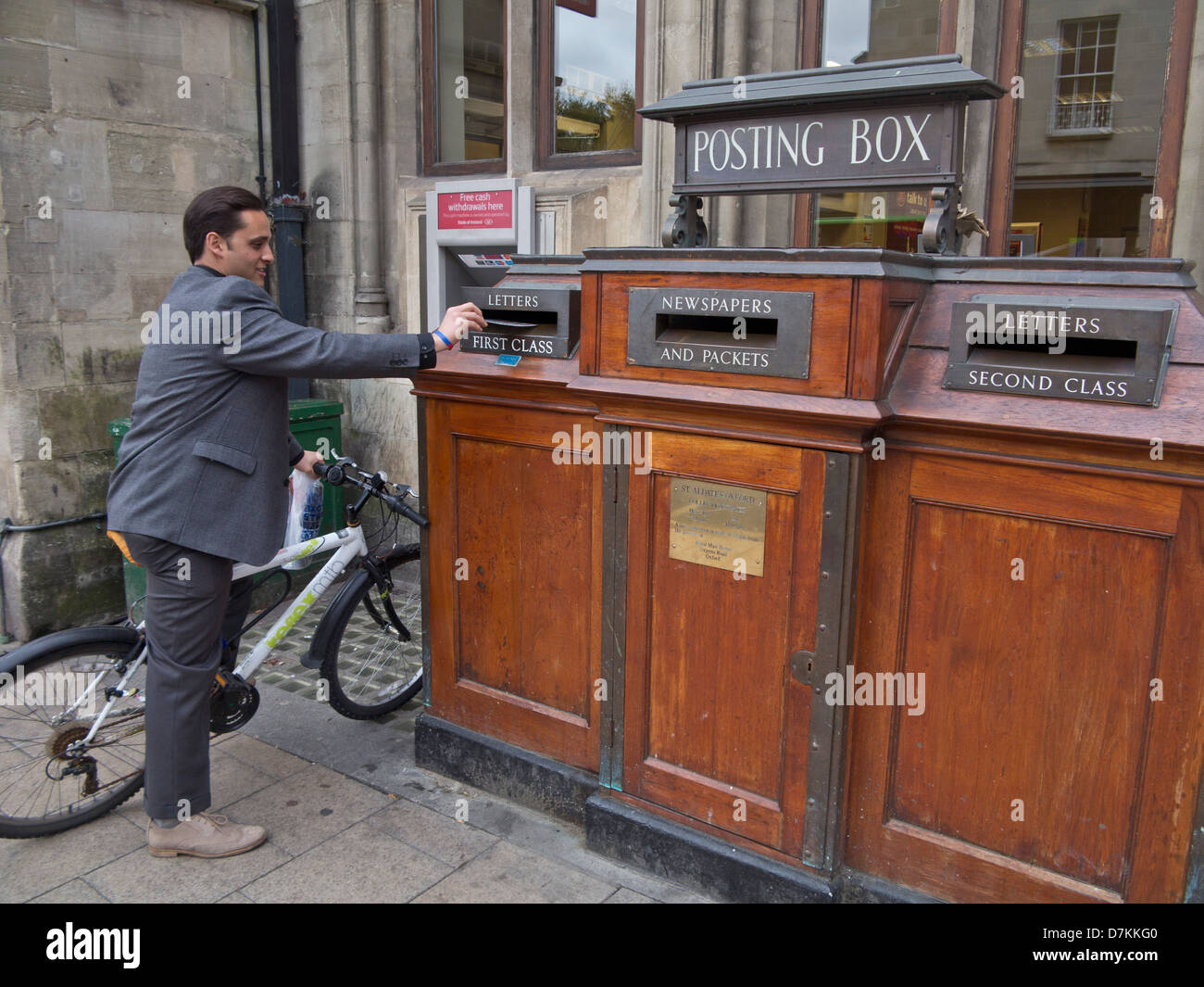 Man posting letter in an old fashioned Post Office in Oxford, England