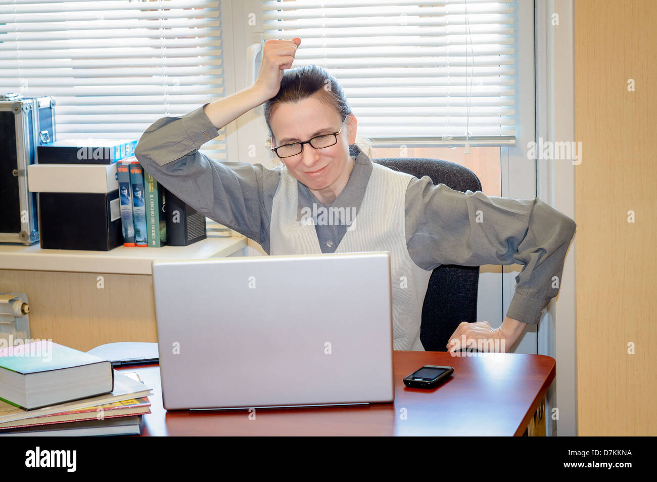 A fifty years old woman very angry with the modern technology Stock Photo