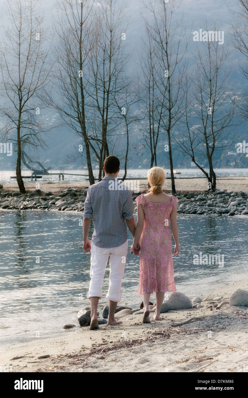a couple is walking on the beach Stock Photo