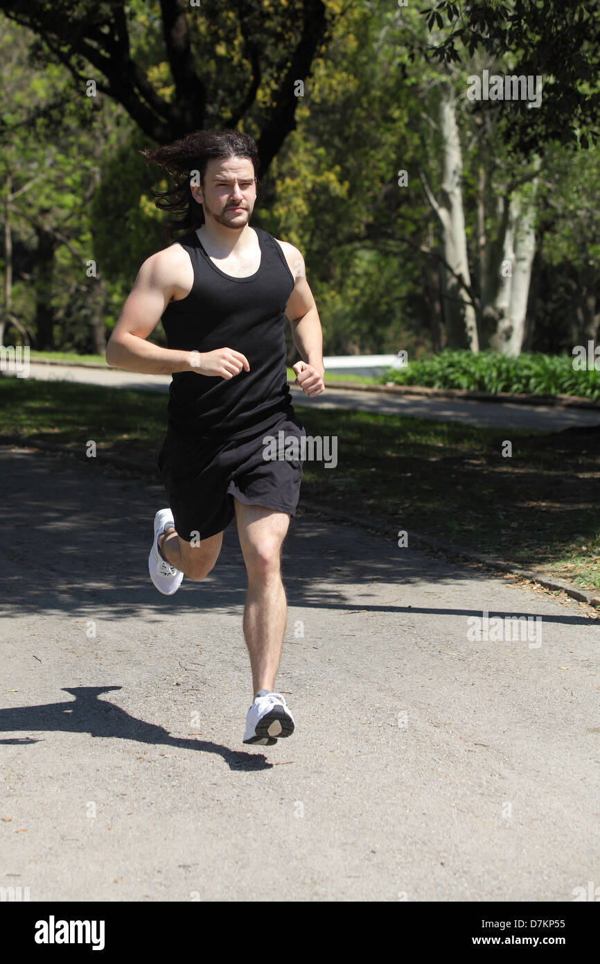 Front view of an sportsman running on a park Stock Photo