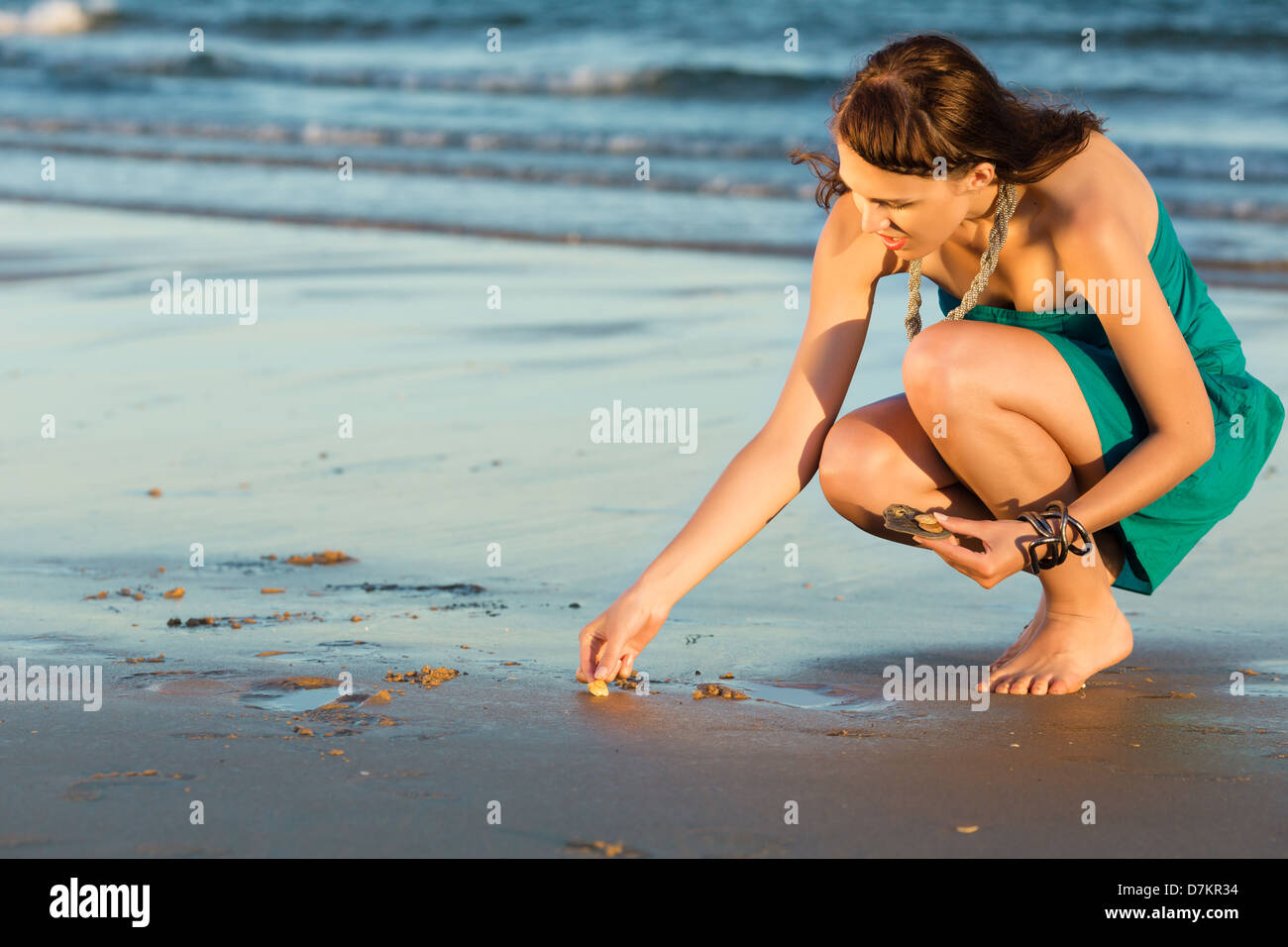 Women looking for sea shells in romantic sunset Stock Photo