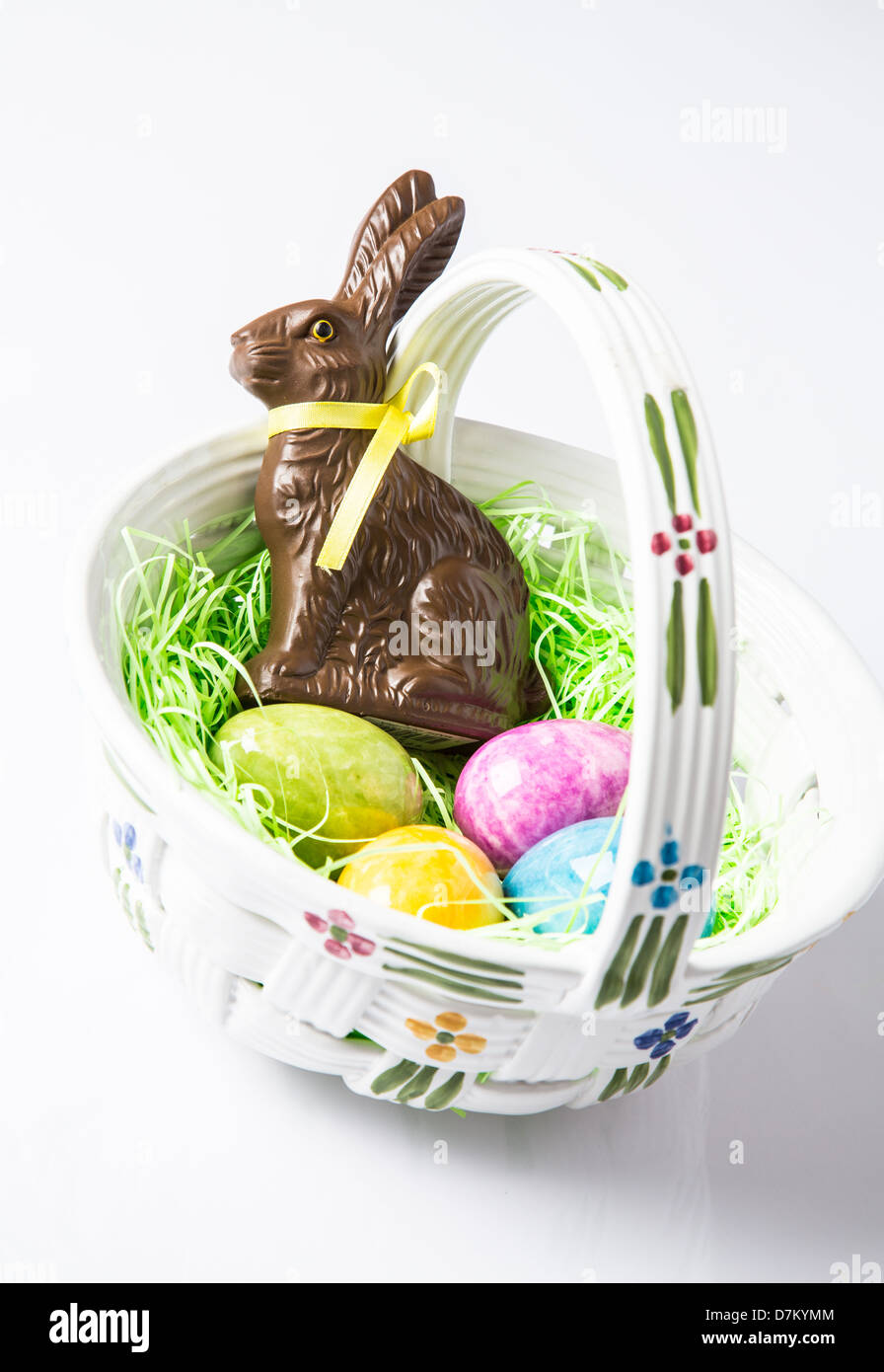 Easter eggs and a Chocolate Rabbit in a ceramic basket. Holiday Traditions Stock Photo
