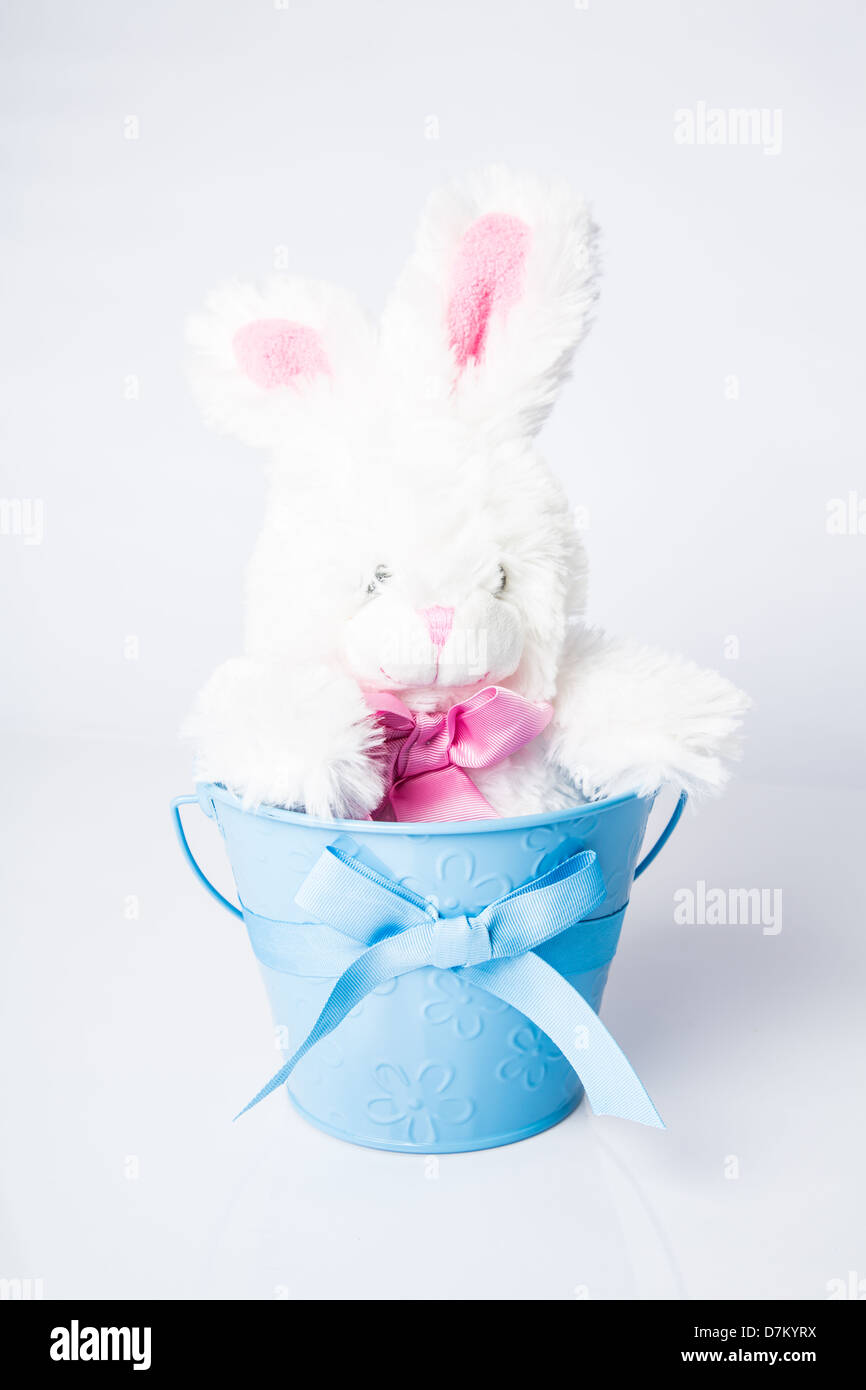 Bunny in a Pail, Easter toy in a pastel pail with ribbon. Stock Photo