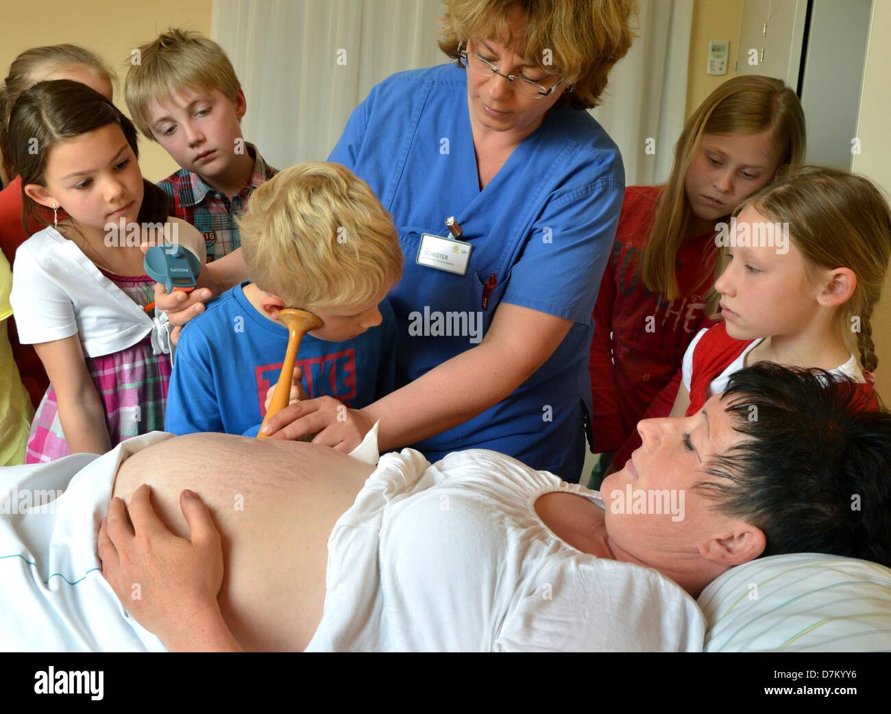 Third graders of the primary school Halle-Kröllwitz accompany the head physician of the hospital St. Elisabeth and St. Barbara Sven Seeger to an examination of a pregnant woman in Halle, Germany, 25 April 2013. Photo:  Waltraud Grubitzsch Stock Photo