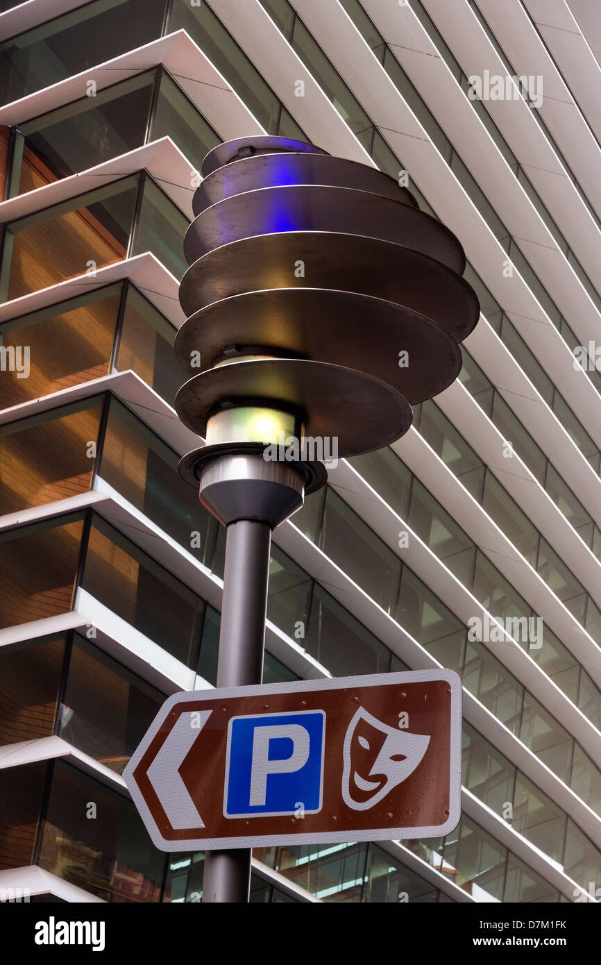 Parking direction sign and modern streetlight and front facade of the ...