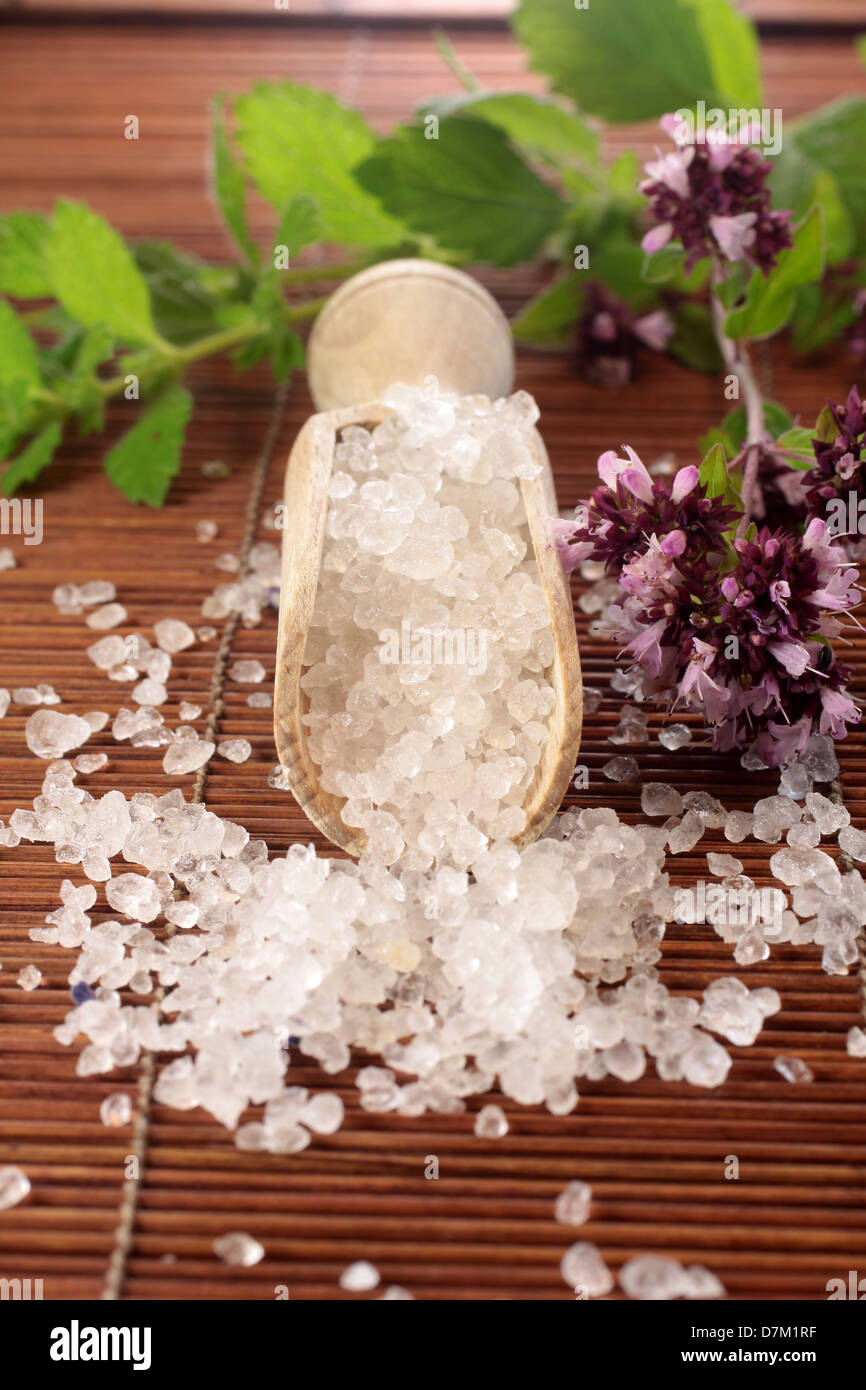 Small wooden shovel with bath salt and herbs Stock Photo