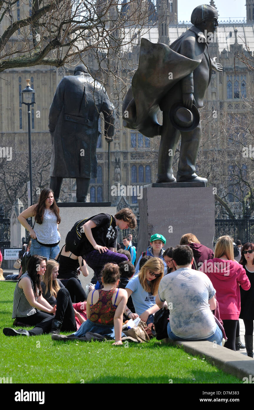 London, England, UK. People relaxing in Parliament Square statues of