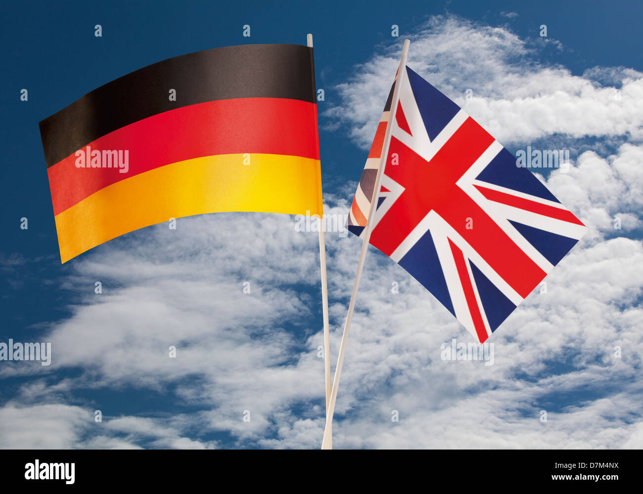 English flag and German flag against cloudy sky Stock Photo