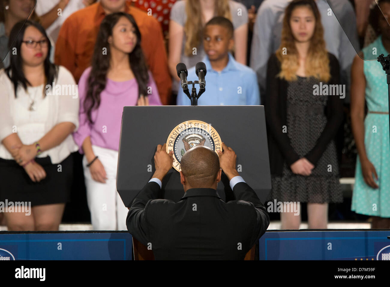 Presidential aide adjusts seal of the President of the United States of America on  lectern before Pres. Obama's speech Stock Photo