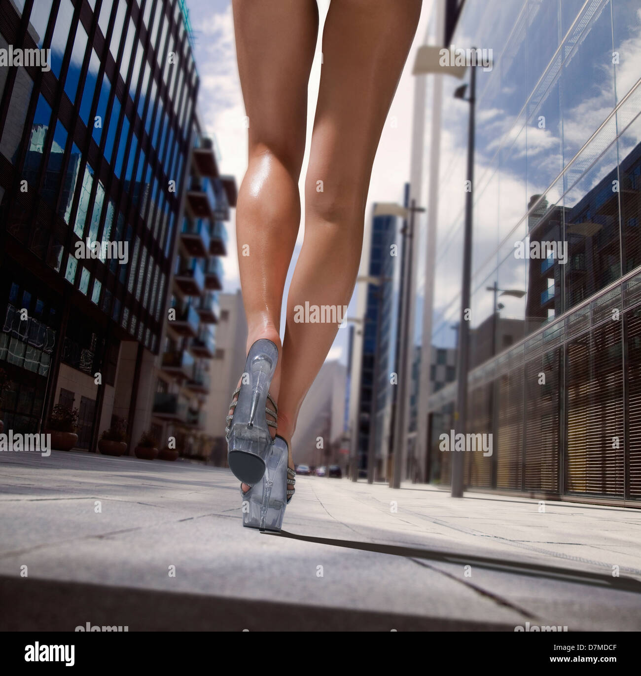 girl with great legs walking down a street during summertime Stock Photo