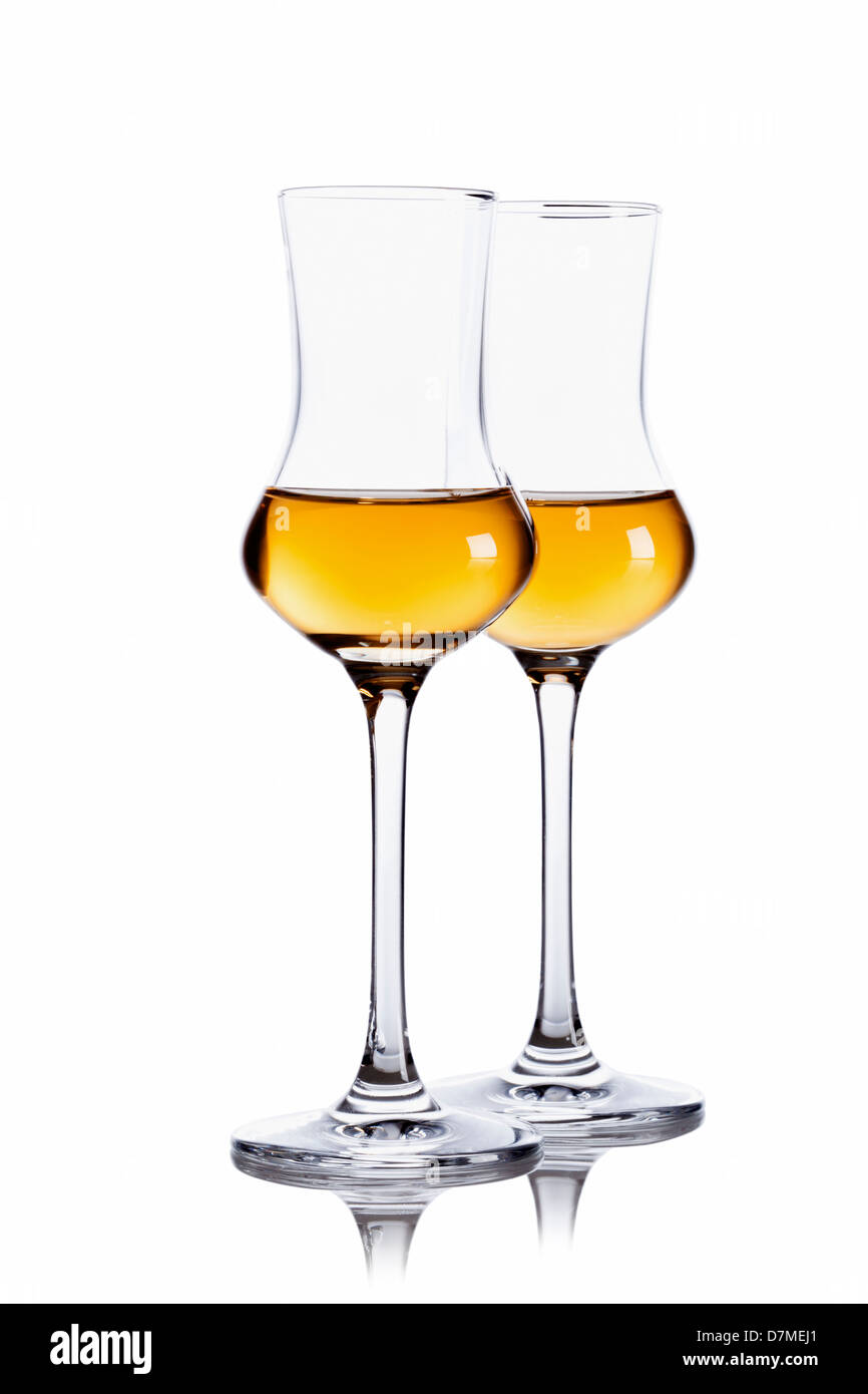 Two glasses of dark Grappa isolated on white background Stock Photo