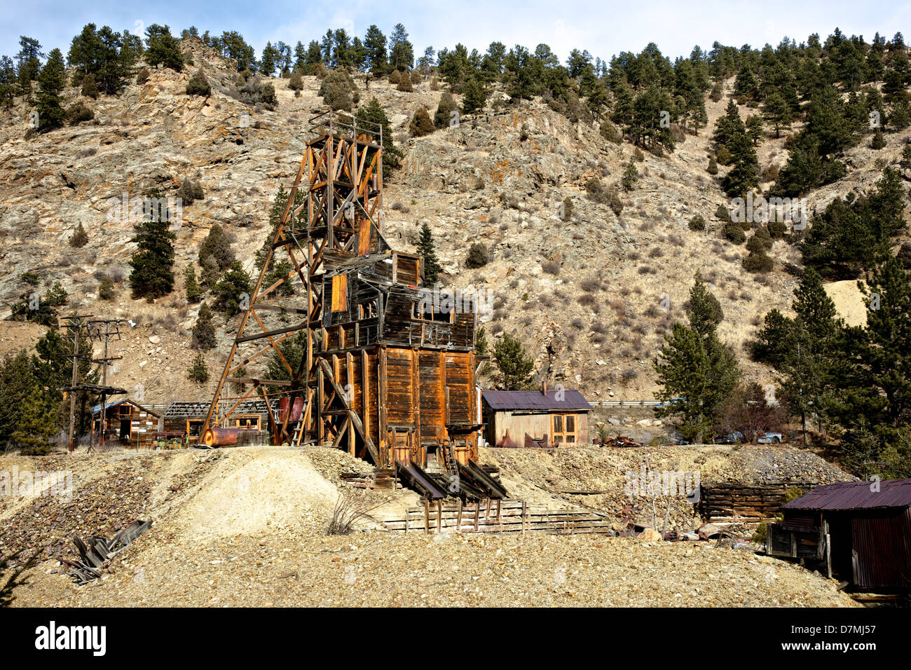 Rustic old gold mine in the Rocky Mountains clings to a hillside Stock
