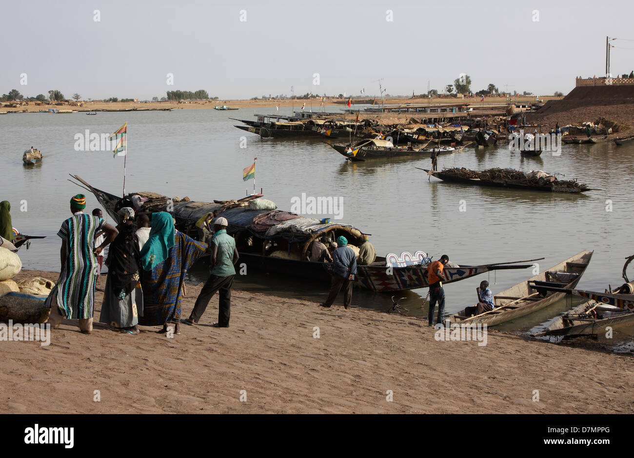 Local men and women waiting to buy fish from fishing boats, early morning, Mopti fish market on River Niger, Mali Stock Photo