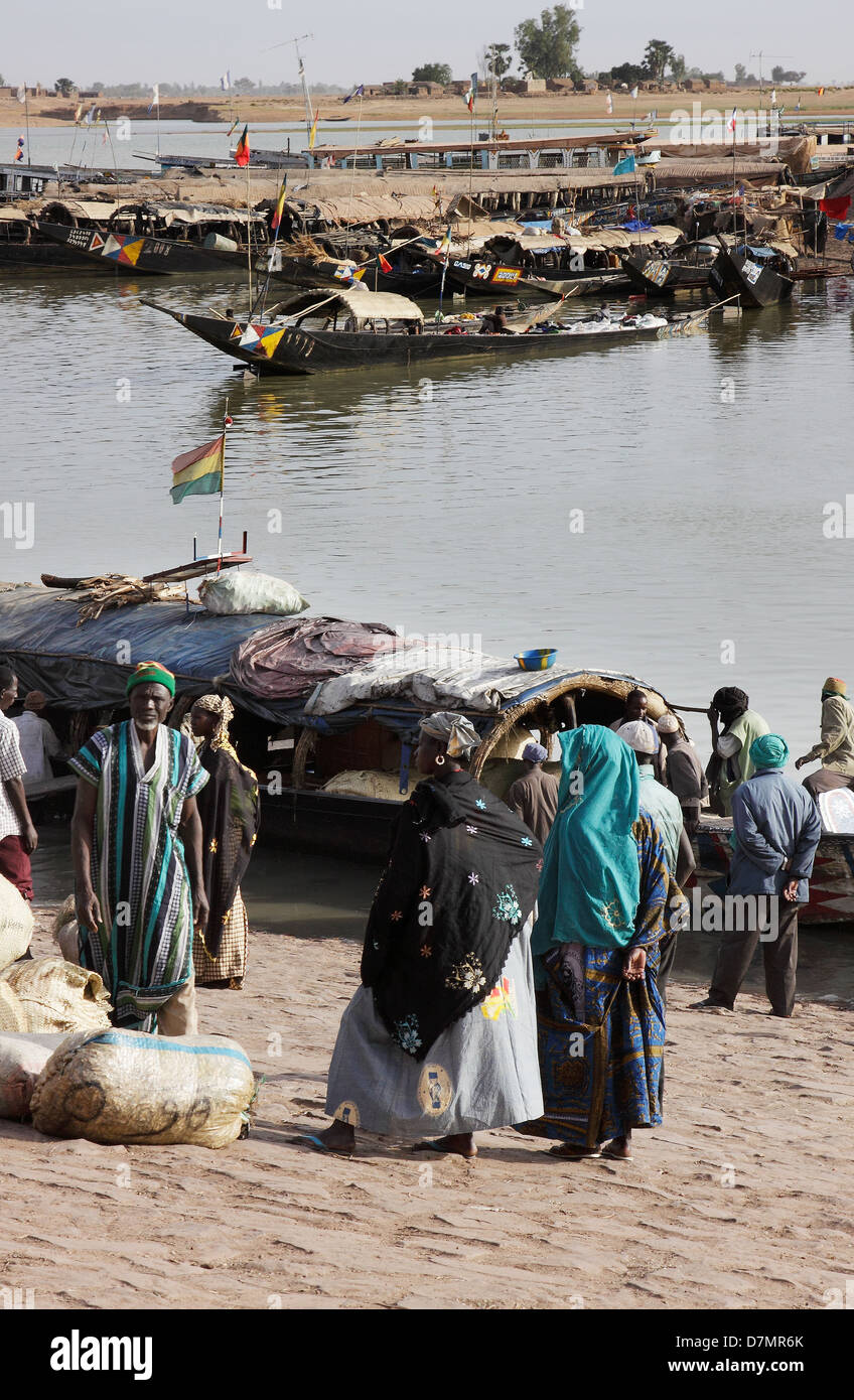 Local men and women waiting to buy fish from fishing boats, early morning, Mopti fish market on River Niger, Mali Stock Photo