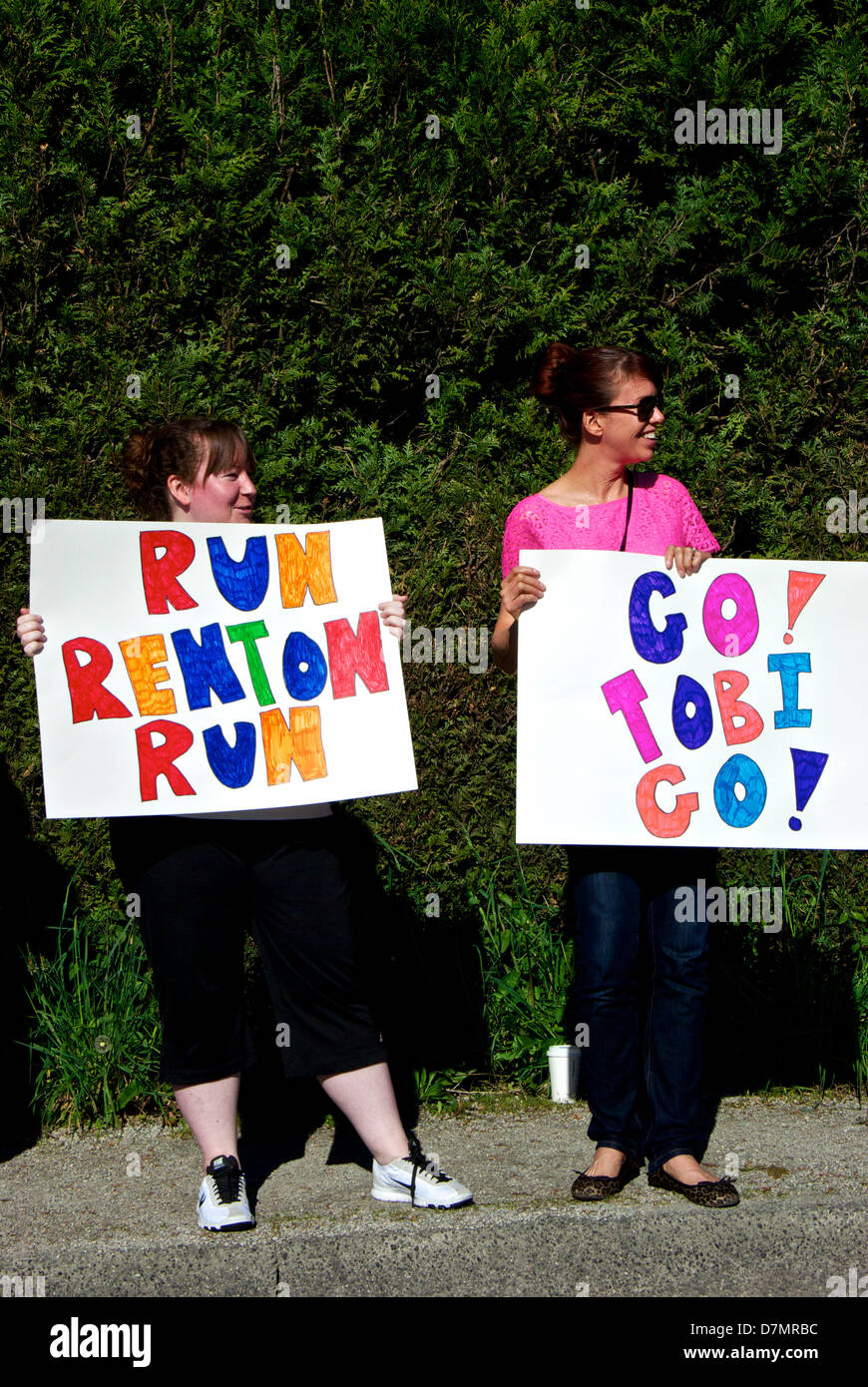 Supporters of two competitors in the 2013 Vancouver BMO International Marathon on side of race course route Stock Photo