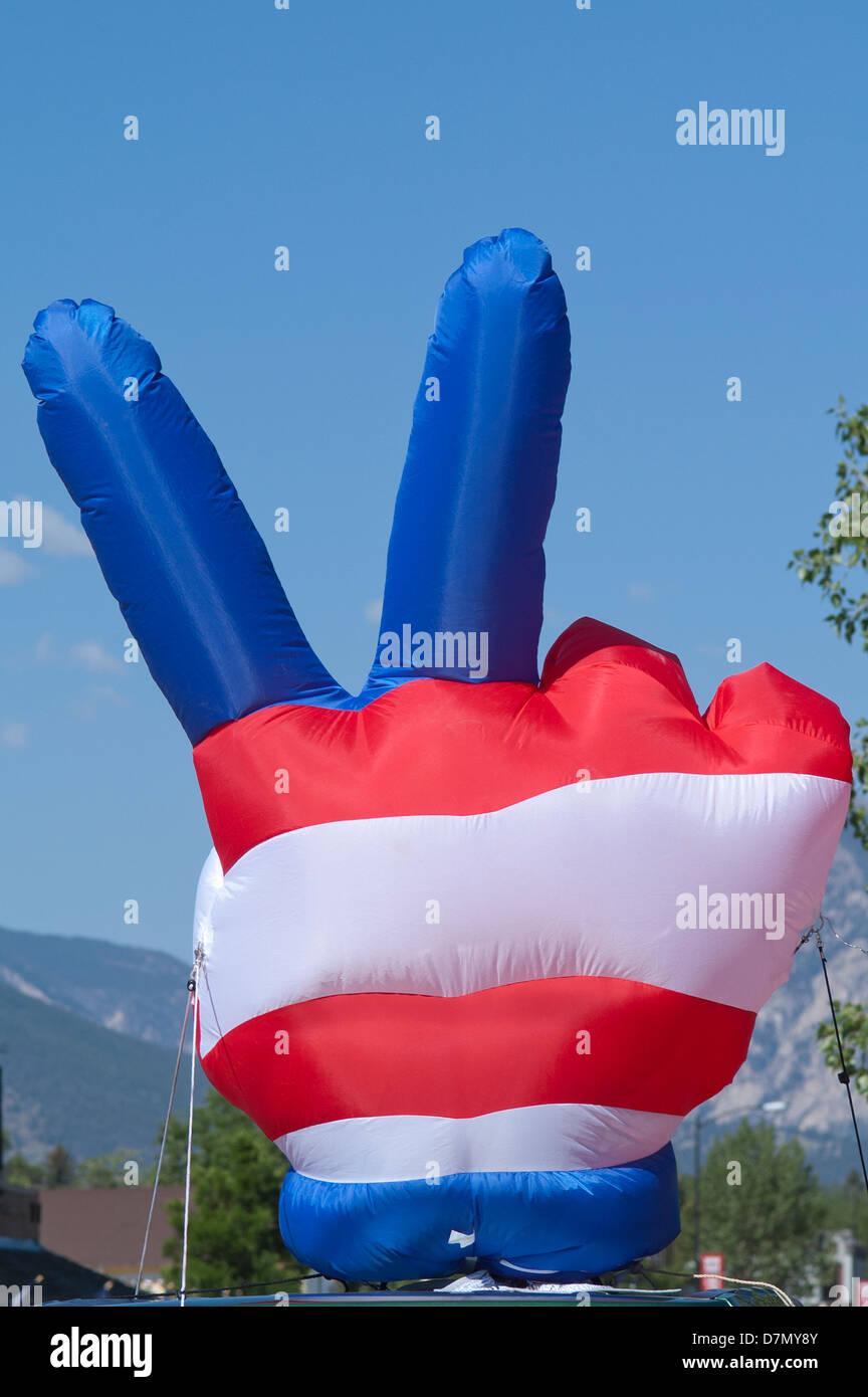 A large balloon shaped like a hand showing the 'peace' sign is decked out in red, white and blue. There is copy space available. Stock Photo