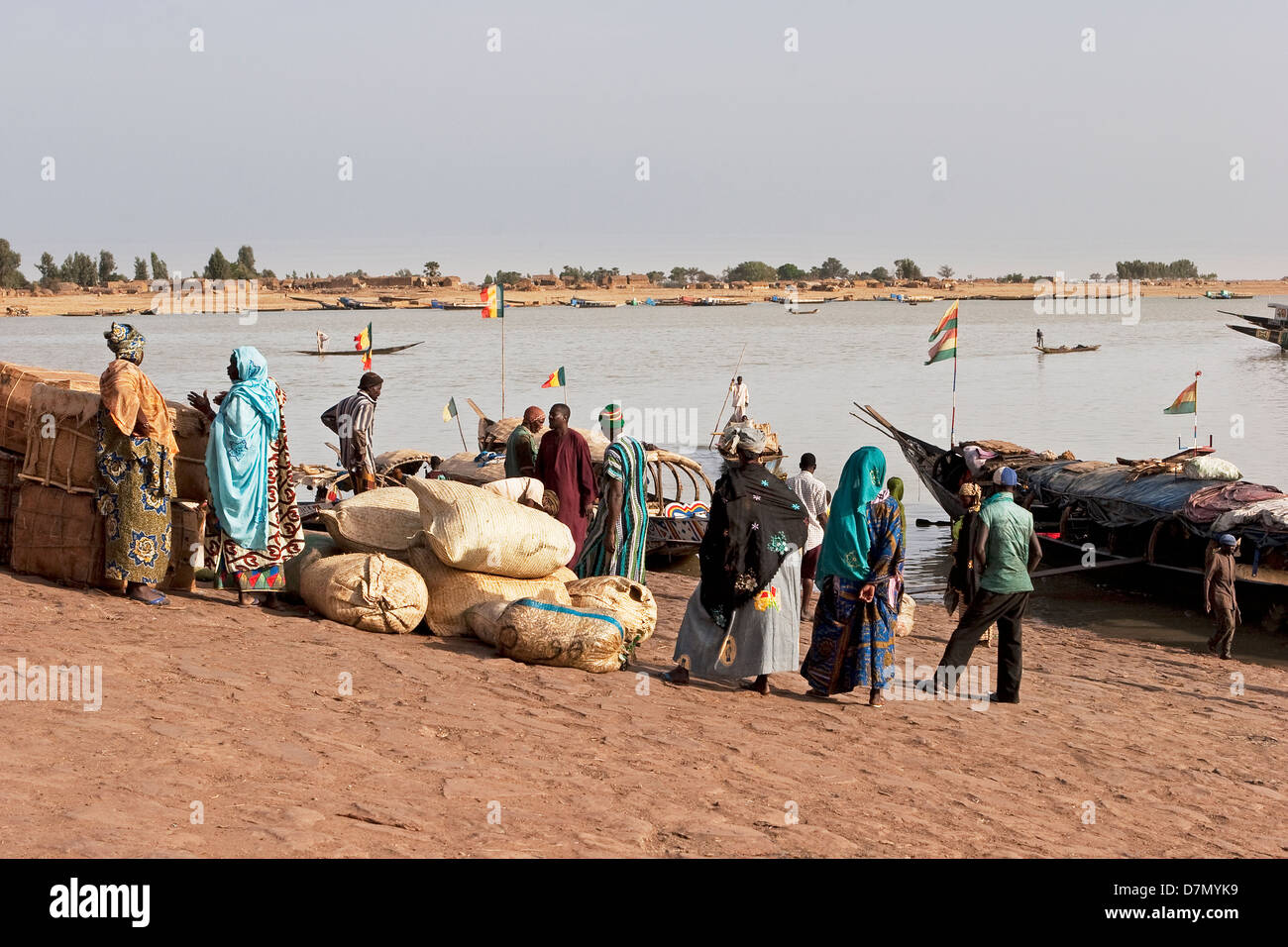Local men and women waiting to buy fish from fishing boats, early morning, Mopti fish market on River Niger, Mali Stock Photo