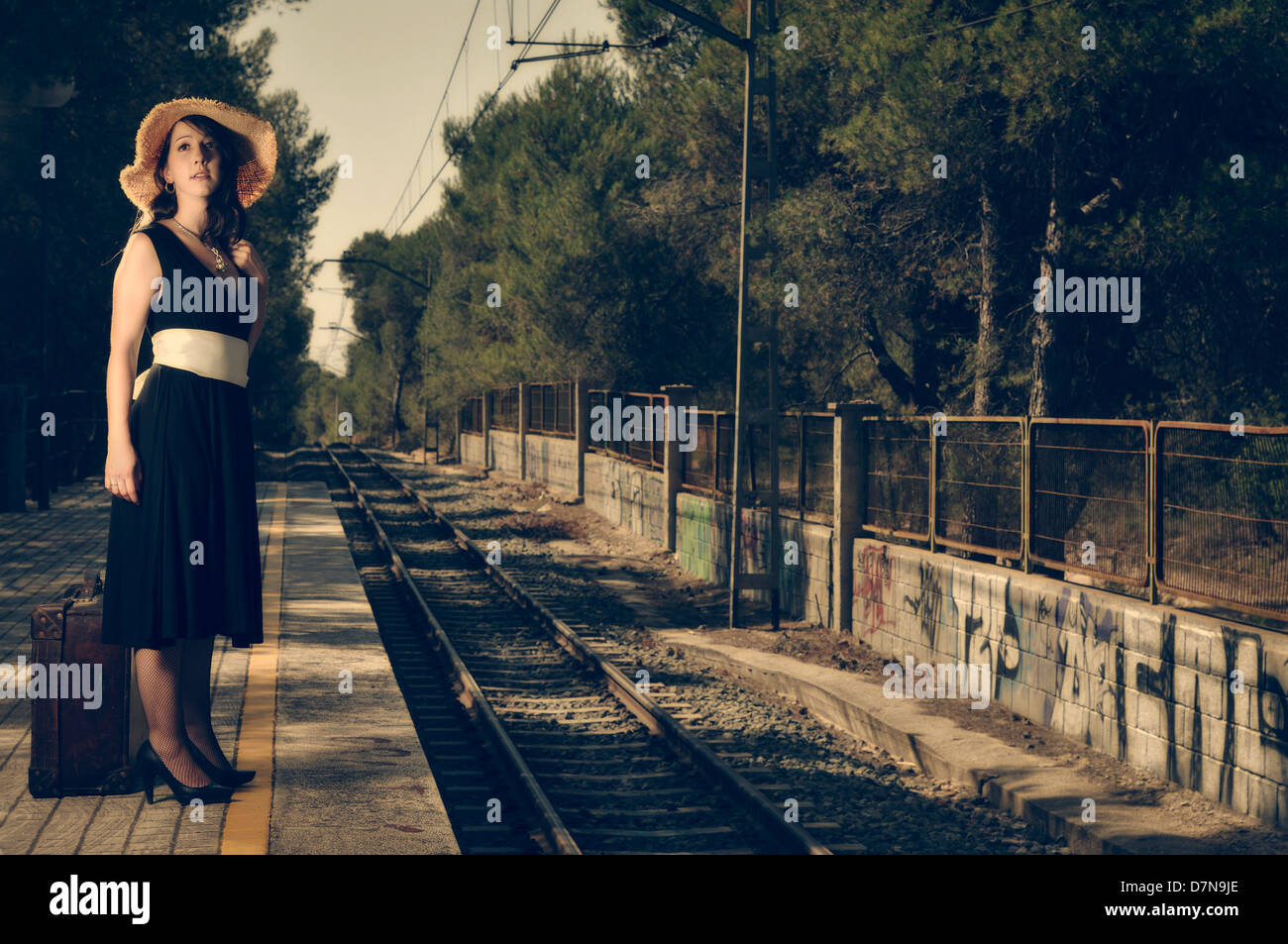 Woman waiting for a train at the station Stock Photo - Alamy