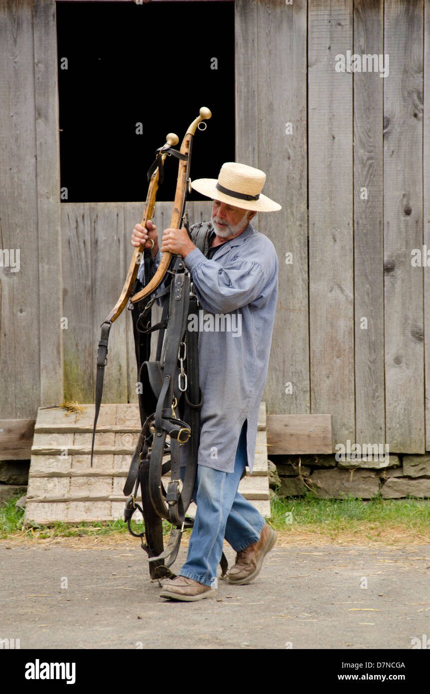 New York, Cooperstown, Farmers' Museum. Brooks Barn. Farm worker and horse harness. Educational, tourism, or editorial use only. Stock Photo