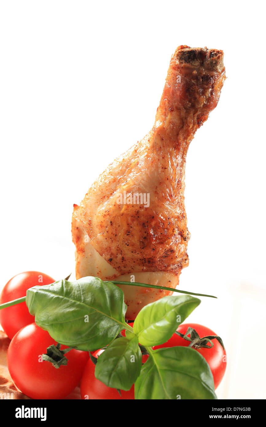 Spicy chicken drumstick and tomatoes - detail Stock Photo