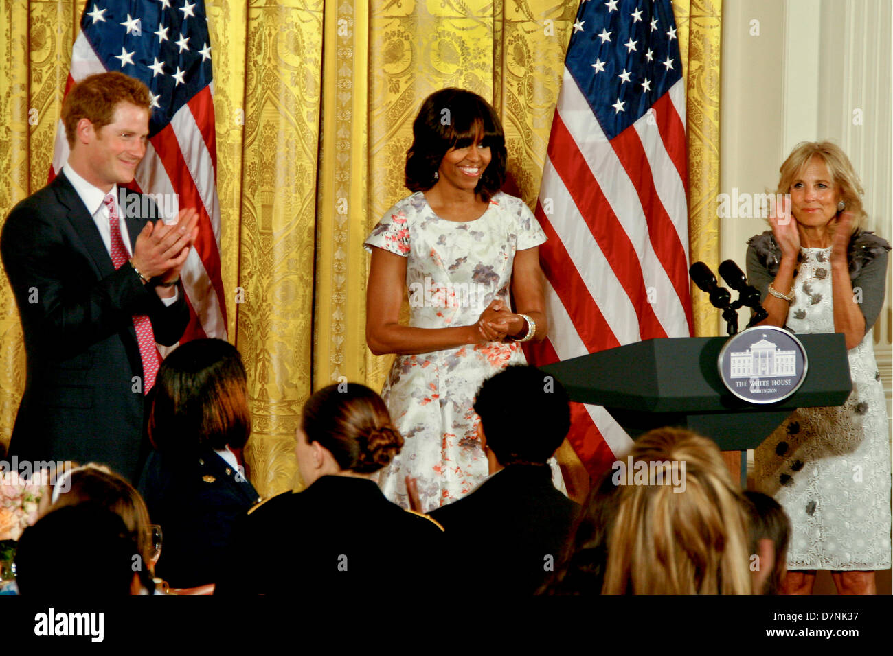 First Lady Michelle Obama with Dr. Jill Biden and Britain's Prince Harry applaud military families during a Joining Forces Mother's Day Tea in the East Room of the White House May 9, 2013 in Washington, DC. Stock Photo