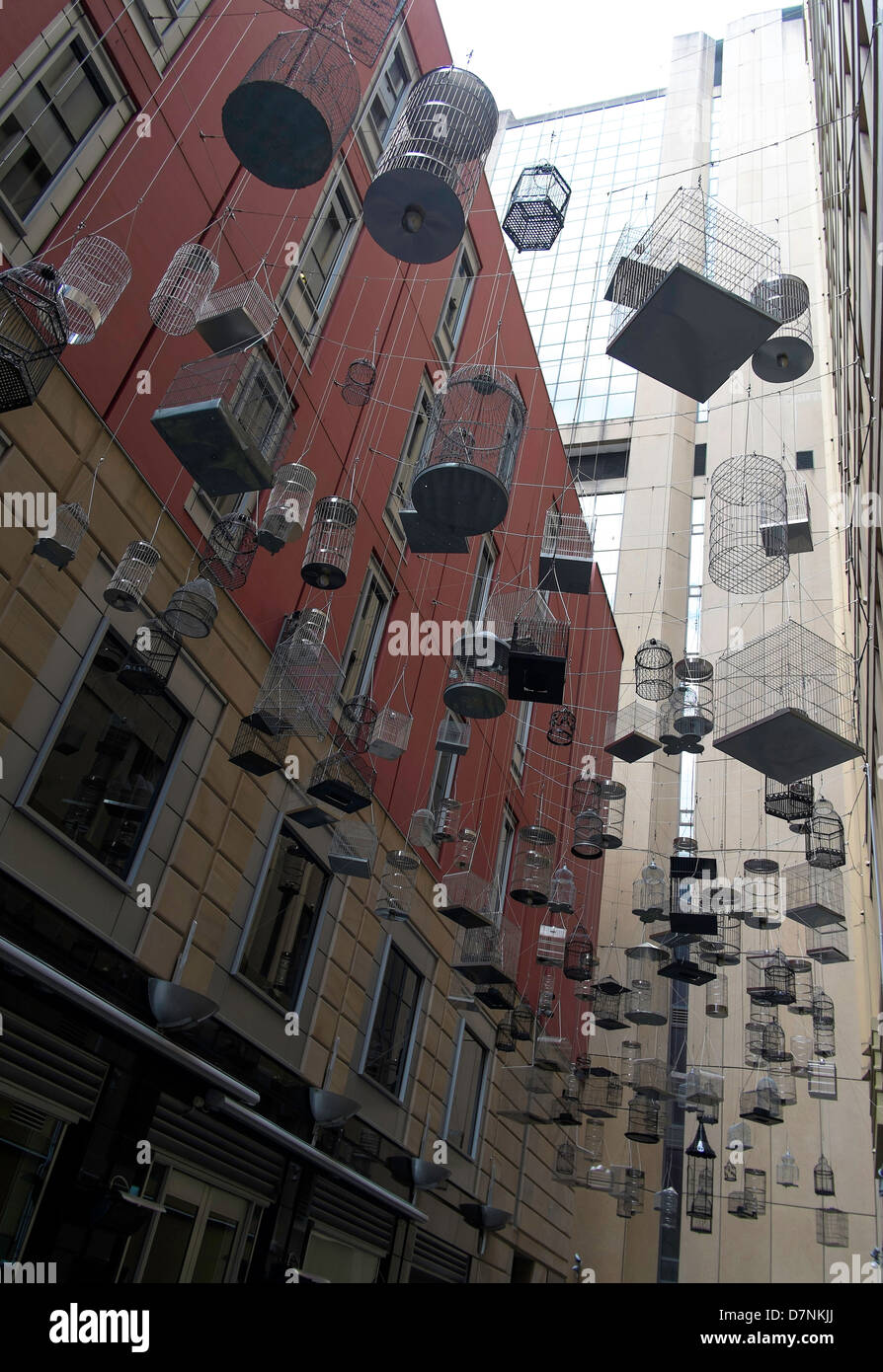Art installation featuring bird cages suspended above a Sydney alley