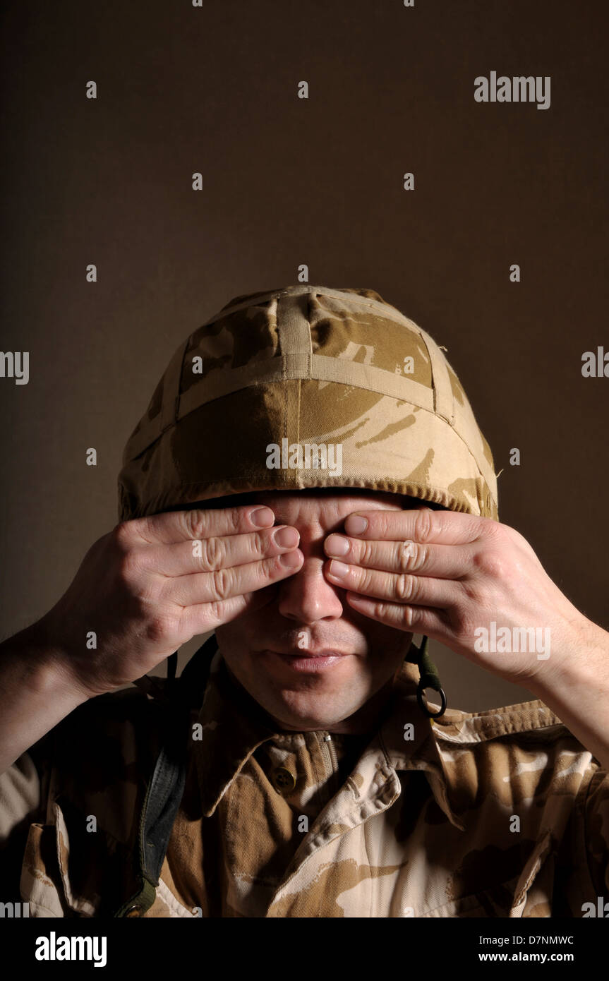 Soldier with hands covering his eyes. Soldier is wearing British