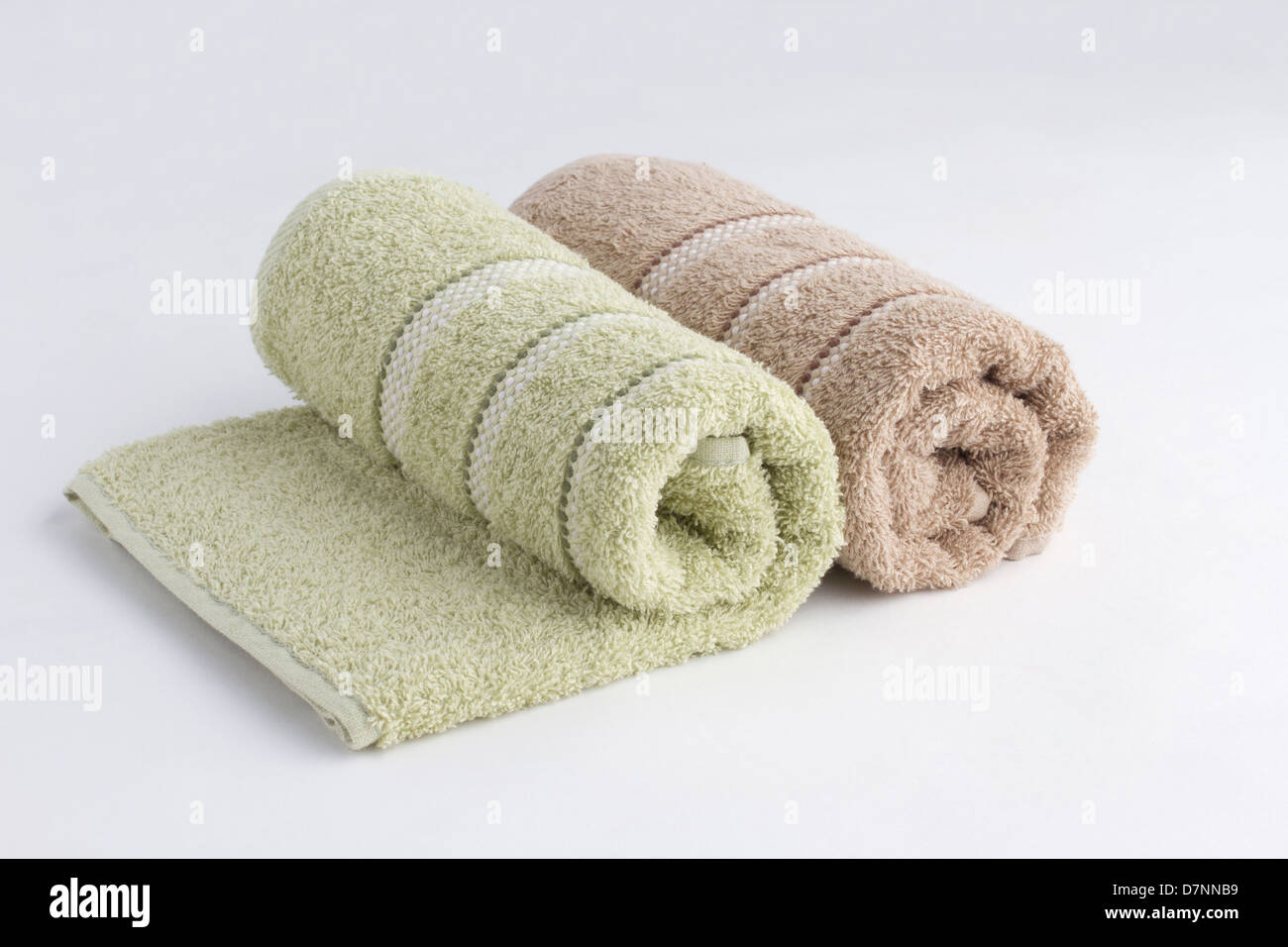 Green and brown towels rolled up on white background Stock Photo