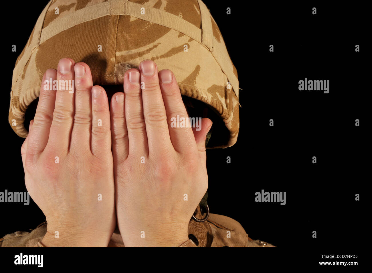 Soldier with hands covering his face. Soldier is wearing British