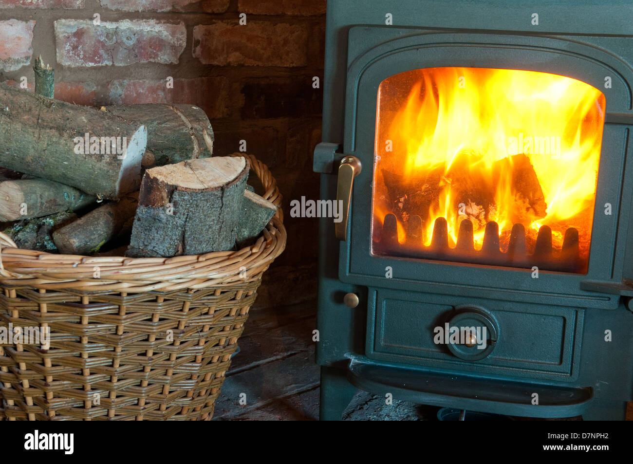 Wood burning stove with a basket of logs Stock Photo Alamy