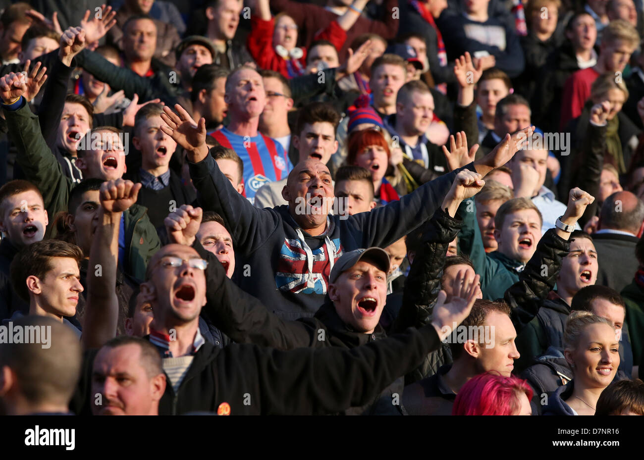 Football fans singing and chanting in the stands. Stock Photo