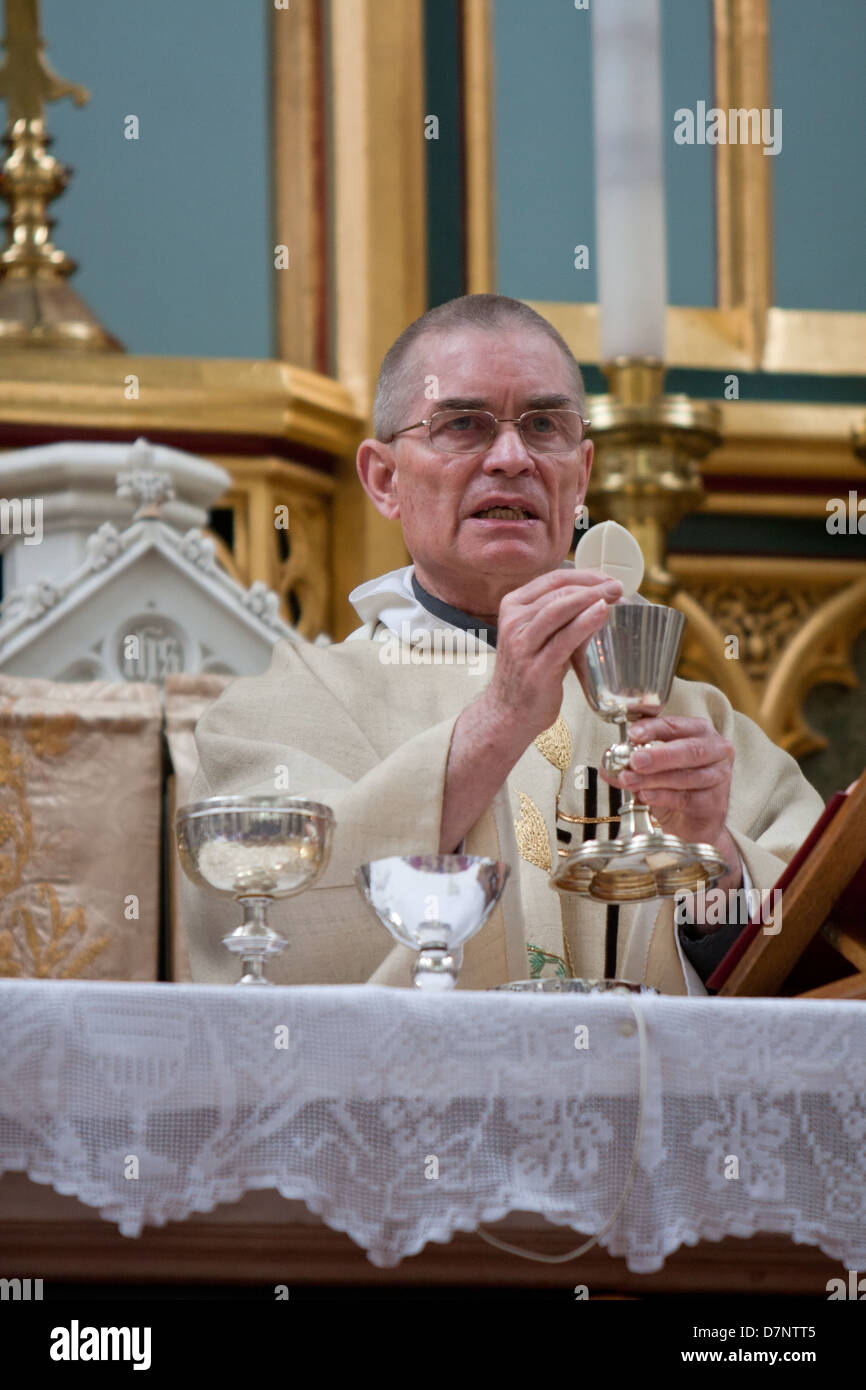 A Catholic priest celebrates mass with the Holy Eucharist and chalice ...